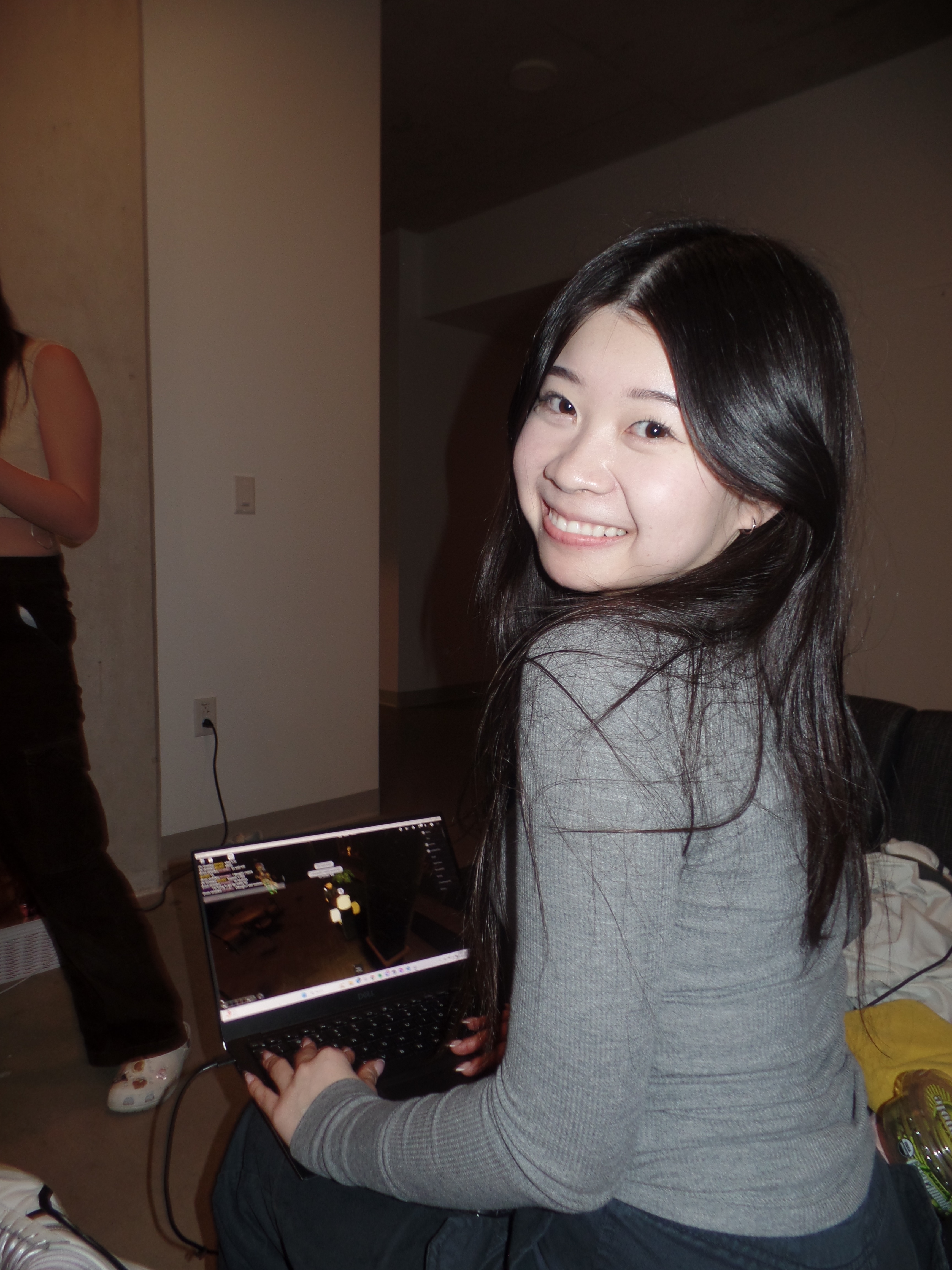 Natasha playing Roblox on laptop, looking back at camera